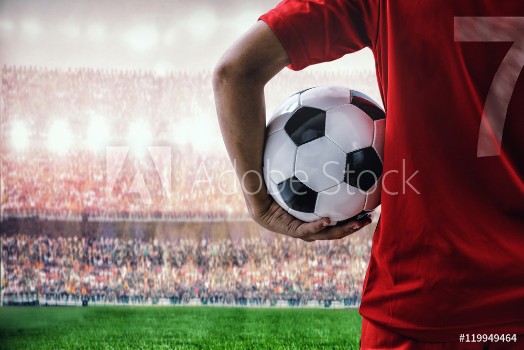 Picture of soccer football player in red team concept holding soccer ball in the stadium